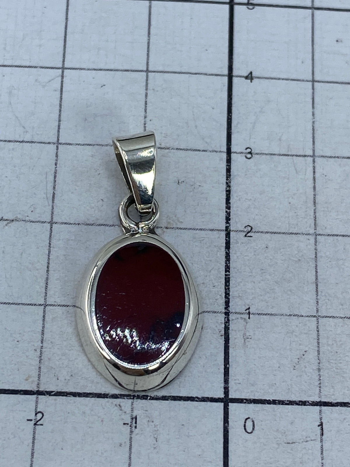 Reverso del dije plateado mostrando acabado y Quinto 925