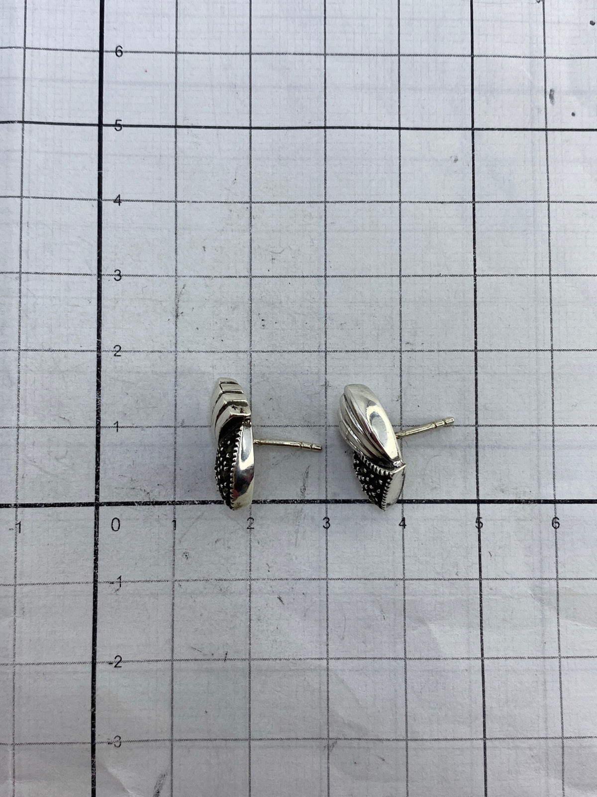 Aretes en la mano demostrando el tamaño y peso ligero del par