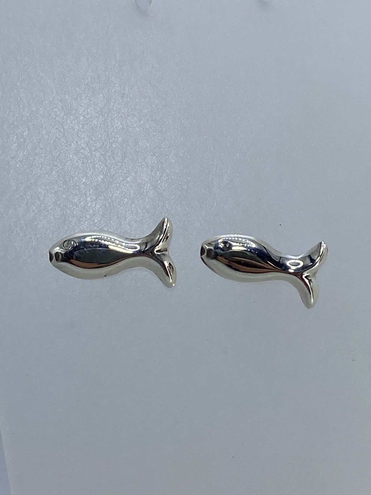Vista frontal de aretes pez en plata 925 brillante