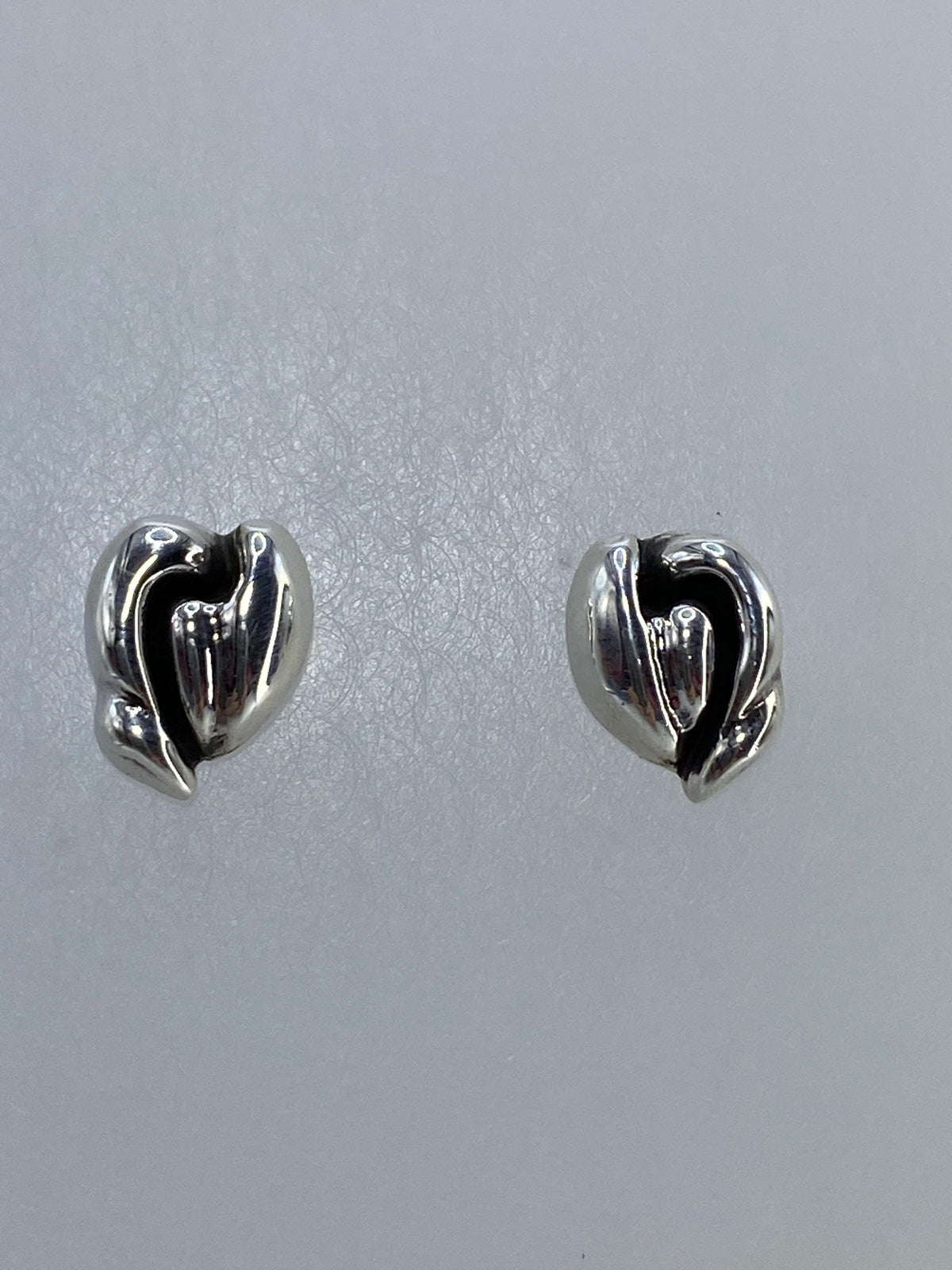 Detalle lateral de un arete corazón mostrando el volumen tridimensional de la técnica cartoneado