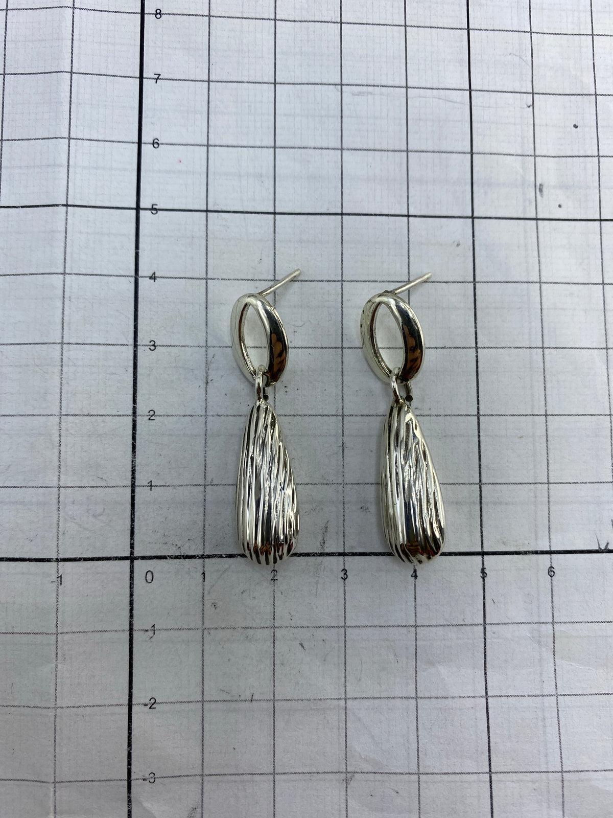 Aretes en estuche azul mostrando el acabado brillante de la plata 925