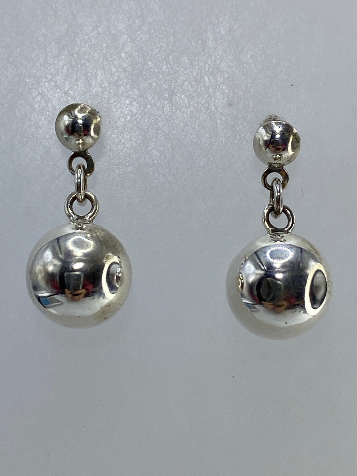 Aretes de plata cartoneado con forma esférica, vista frontal del par