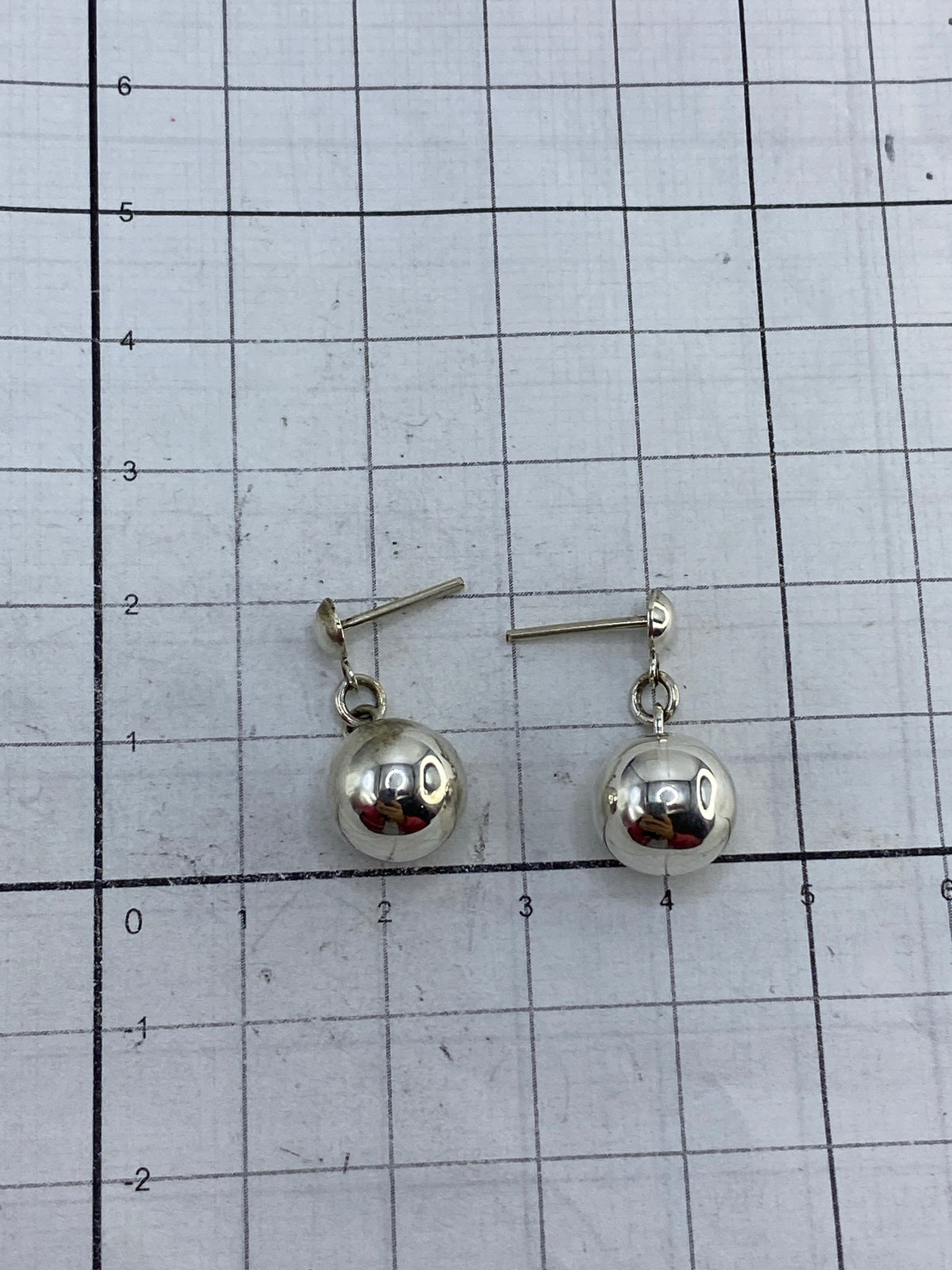 Aretes sobre fondo blanco con cierre de poste plateado visible