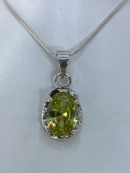 Dije de plata 925 con circonia verde olivo engastada, colgando de cadena de plata