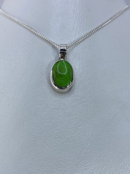 Detalle frontal del dije de coral verde engastado en plata de Taxco