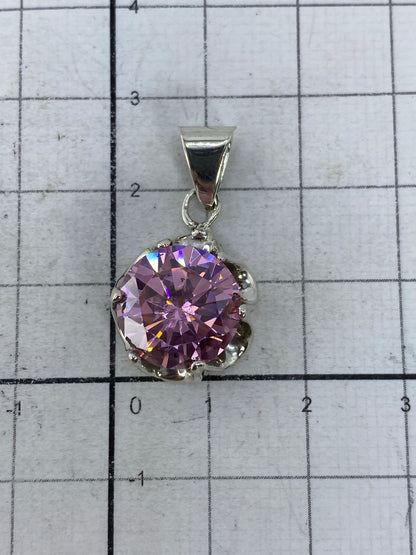 Dije de circonia rosa sobre fondo gris, mostrando el sello 925 en la base