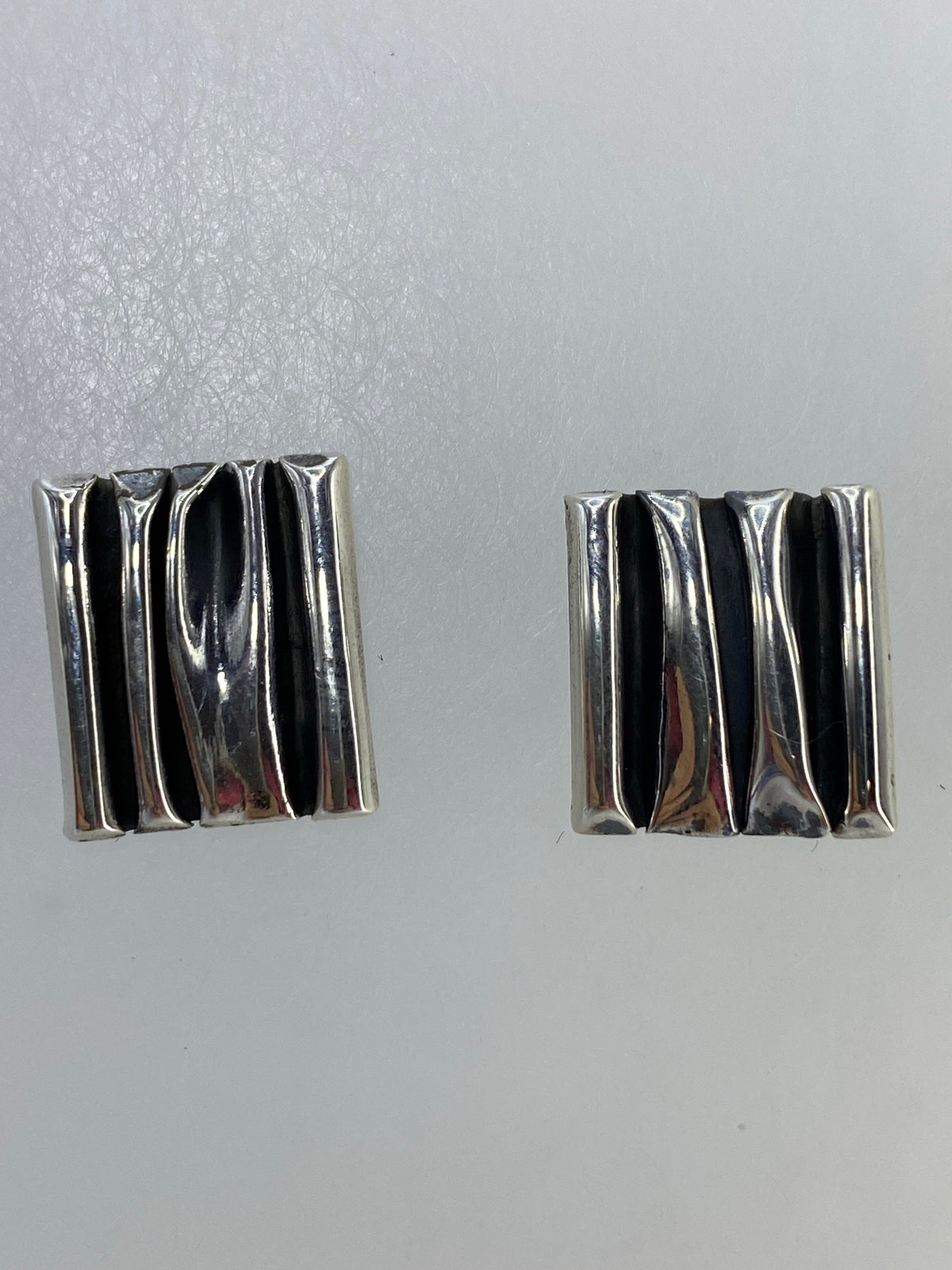 Aretes de plata 925 cartoneado con diseño geométrico minimalista, colocados en par