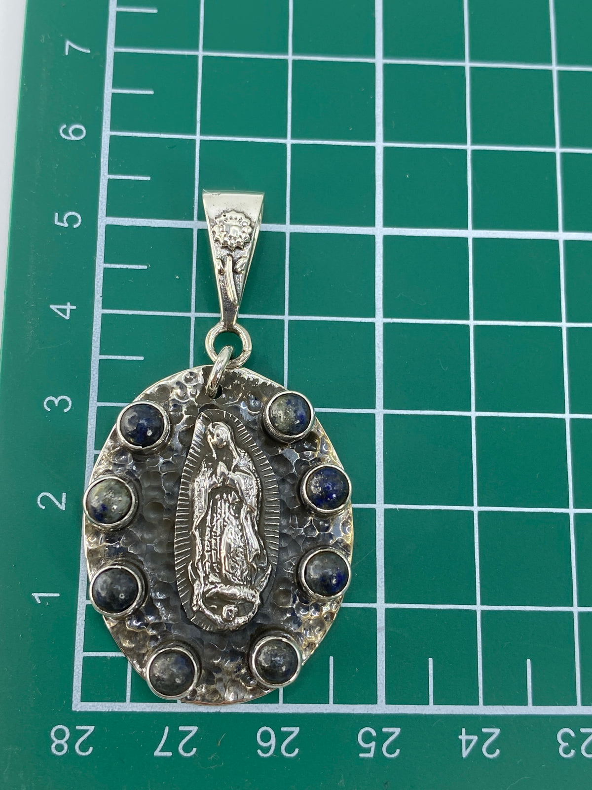 Reverso del dije mostrando el Quinto 925 y la textura de la plata martillada