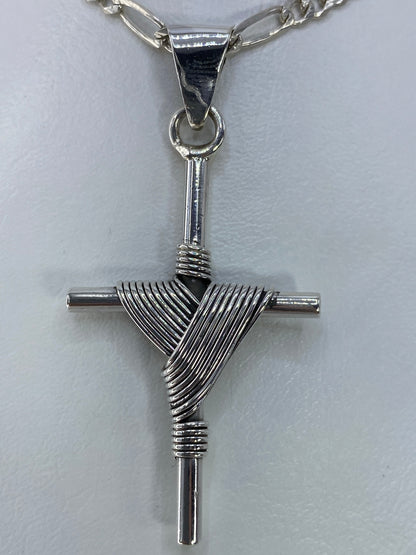 Cruz de plata de 5.3 cm de largo sobre regla, vista de escala y dimensiones reales