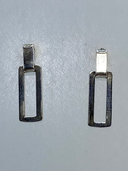 Aretes de plata calado geométrico sobre escala, mostrando 1.49 gramos