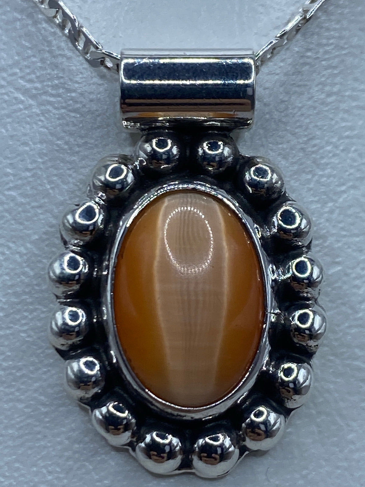 Detalle del engaste a mano en plata con el Quinto mexicano visible