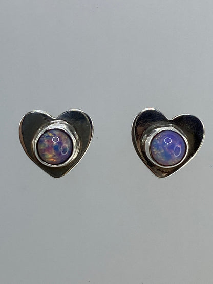 Par de aretes de plata con ópalo de fuego multicolor brillante, mostrando destellos naranja y azul