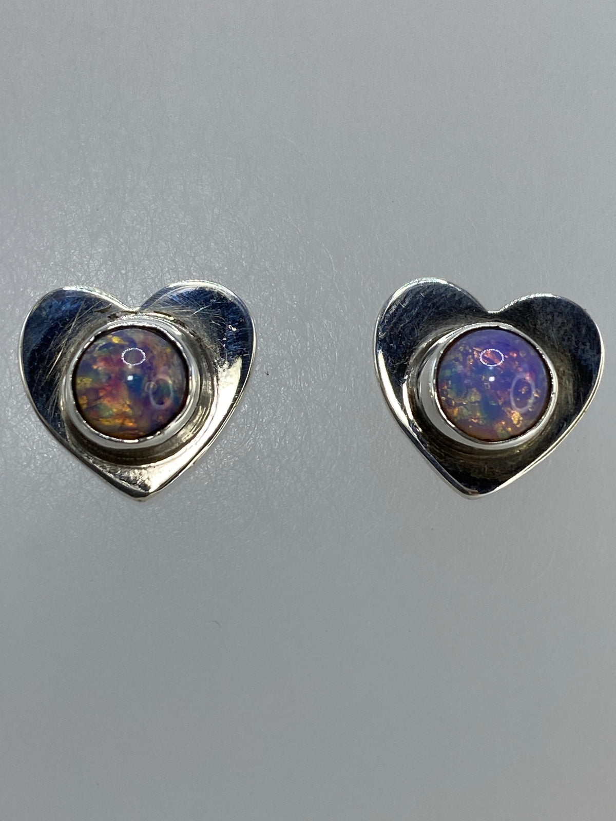 Aretes de plata sobre regla métrica mostrando tamaño en centímetros