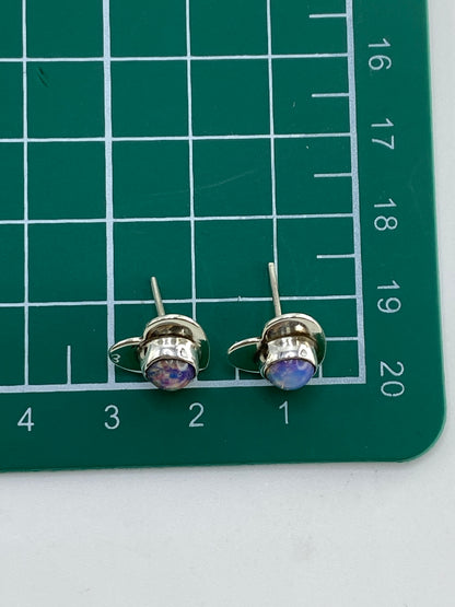 Aretes de plata con ópalo de fuego colocados en balanza digital marcando 2.34 gramos