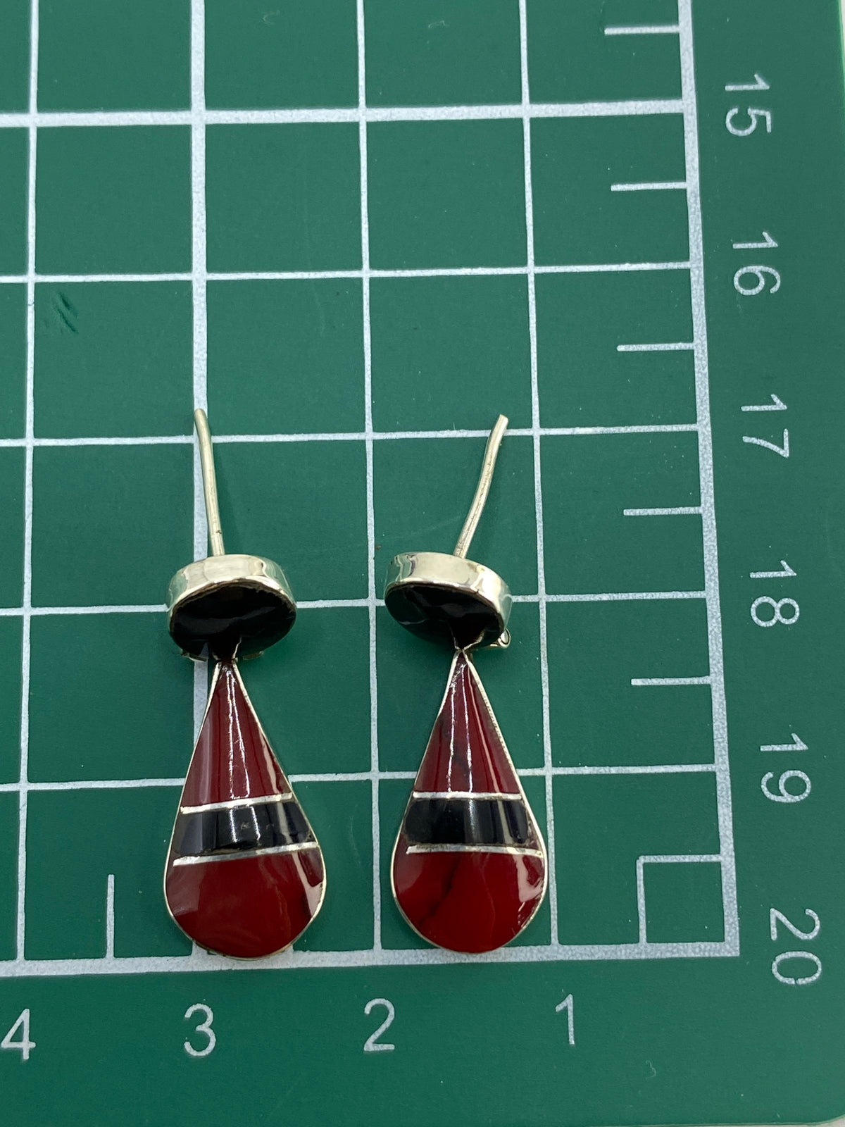 Aretes sobre fondo azul mostrando el acabado pulido de la plata