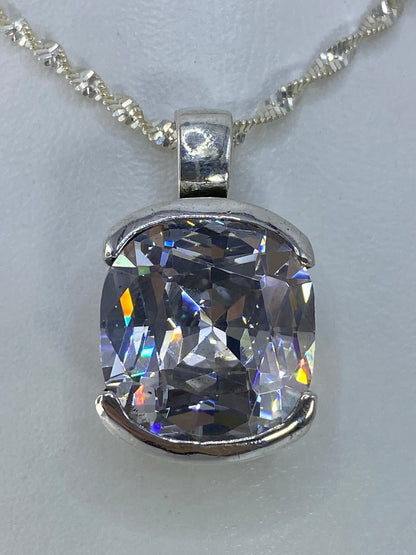 Dije de plata con circonia cristalina en cadena de plata serpentina, detalles de brillo azul y amarillo