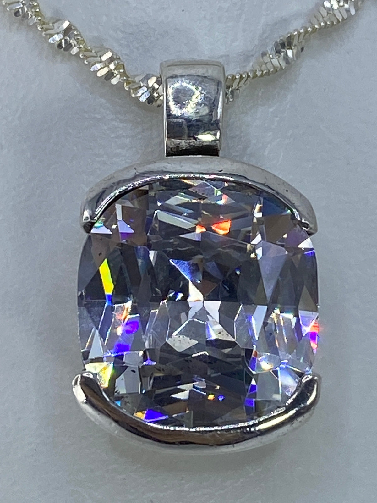 Circonia cristalina grandes destellos de luz reflejada, diamante-like, en cadena de plata