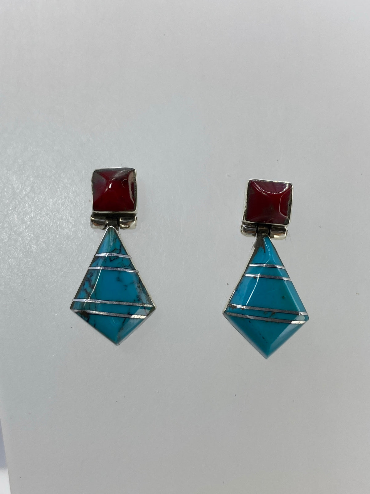 Detalle frontal: cuadrado de coral rojo superior, pirámide de turquesa azul inferior