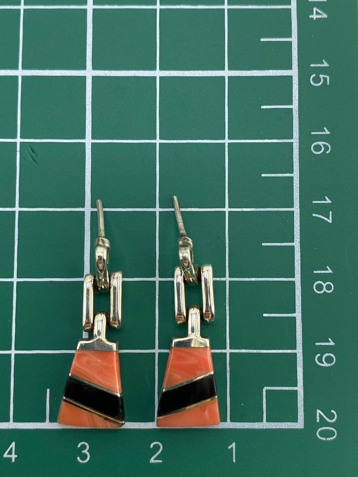 Aretes sobre fondo azul mostrando el contraste del onix y coral rosa