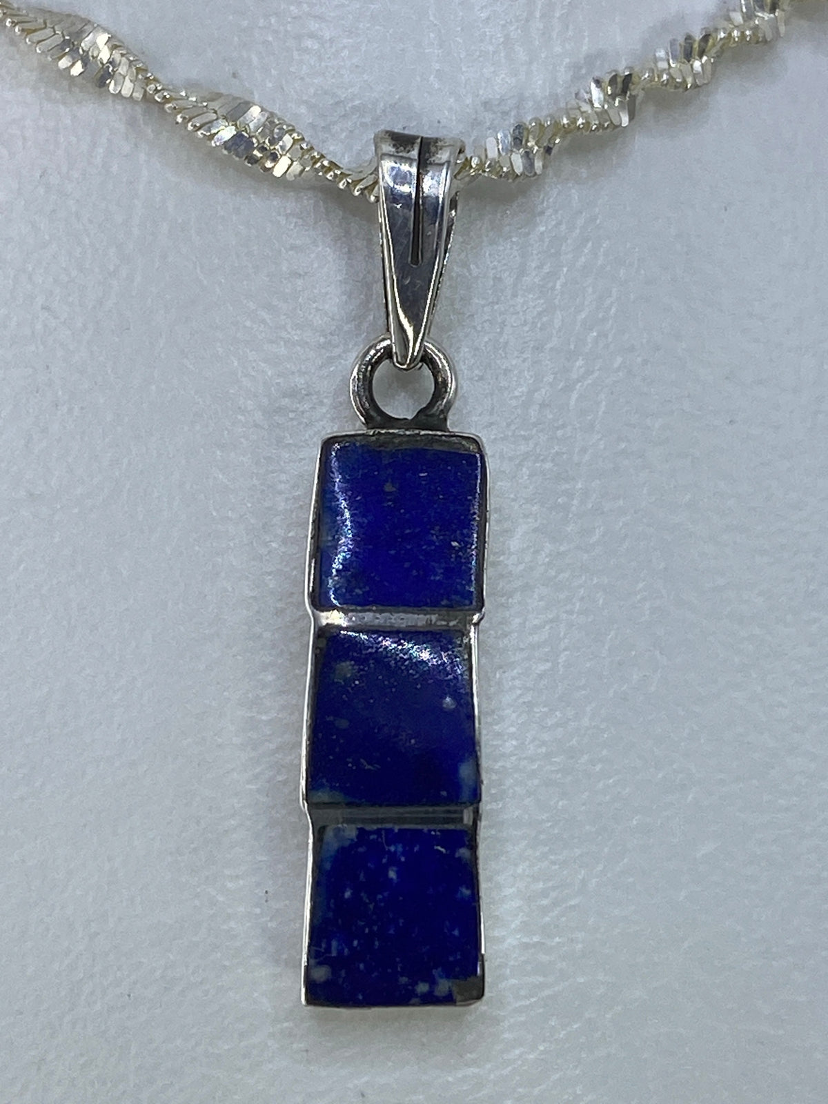 Dije de plata con piedra azul de 3 cm, colgando de cadena plateada