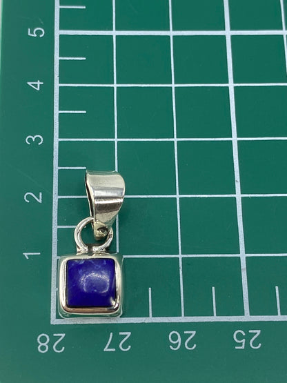 Dije sobre fondo gris mostrando el Quinto 925 en el reverso