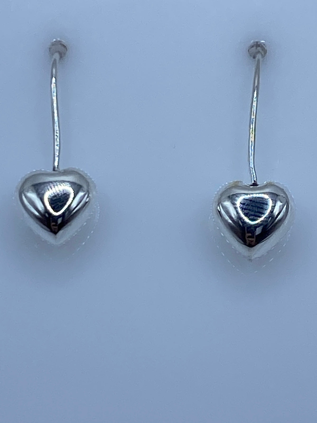 Aretes de plata en forma de corazón, cartoneado de Taxco, par completo sobre fondo blanco
