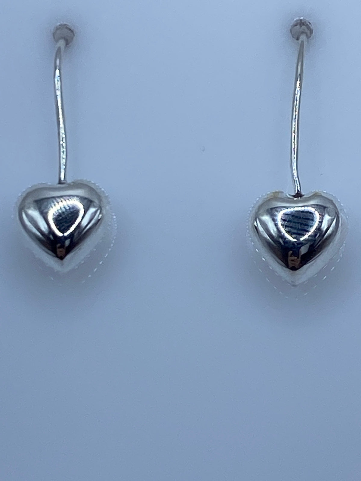 Aretes de corazón en escala de medida mostrando largo de 2.5 cm