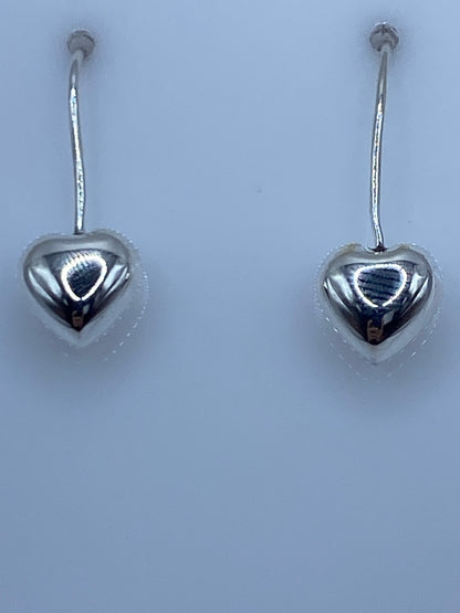Aretes de corazón en escala de medida mostrando largo de 2.5 cm