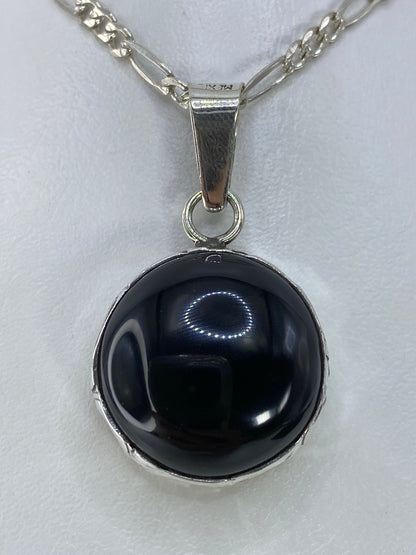 Dije de plata con ónix negro pulido en cadena figaro