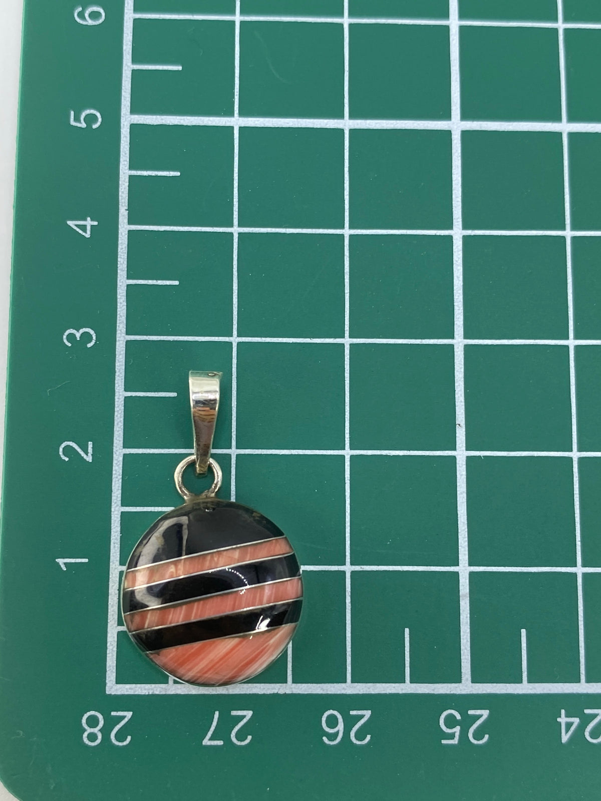 Dije de plata 925 con Quinto sobre fondo gris mostrando la forma compacta