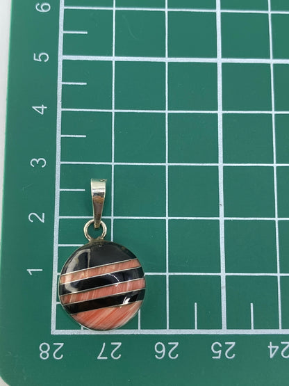 Dije de plata 925 con Quinto sobre fondo gris mostrando la forma compacta