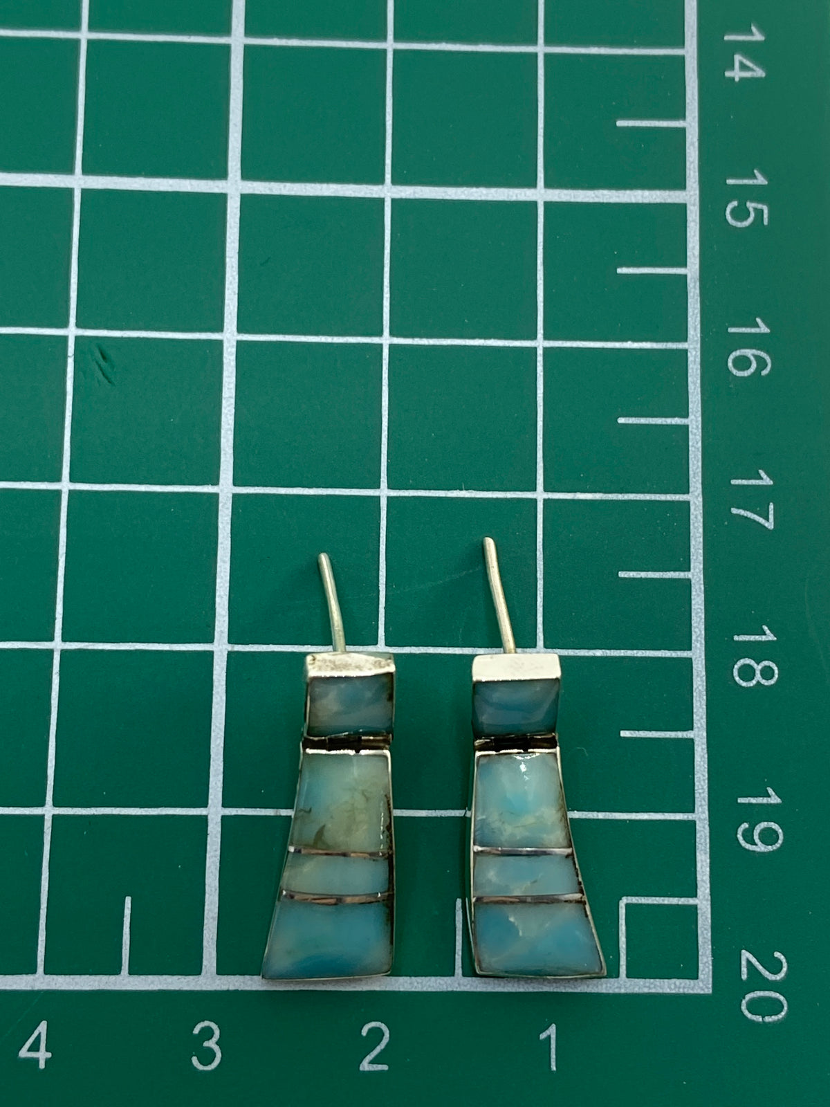 Reverso de los aretes mostrando el poste de plata 950 y el Quinto
