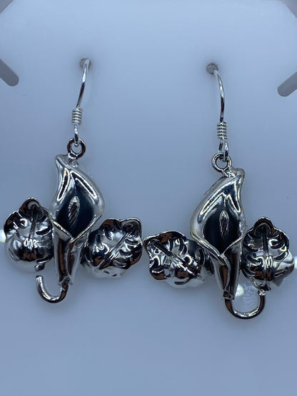 Aretes florales de plata colocados sobre medidor de cm, mostrando los 4.1 cm de largo