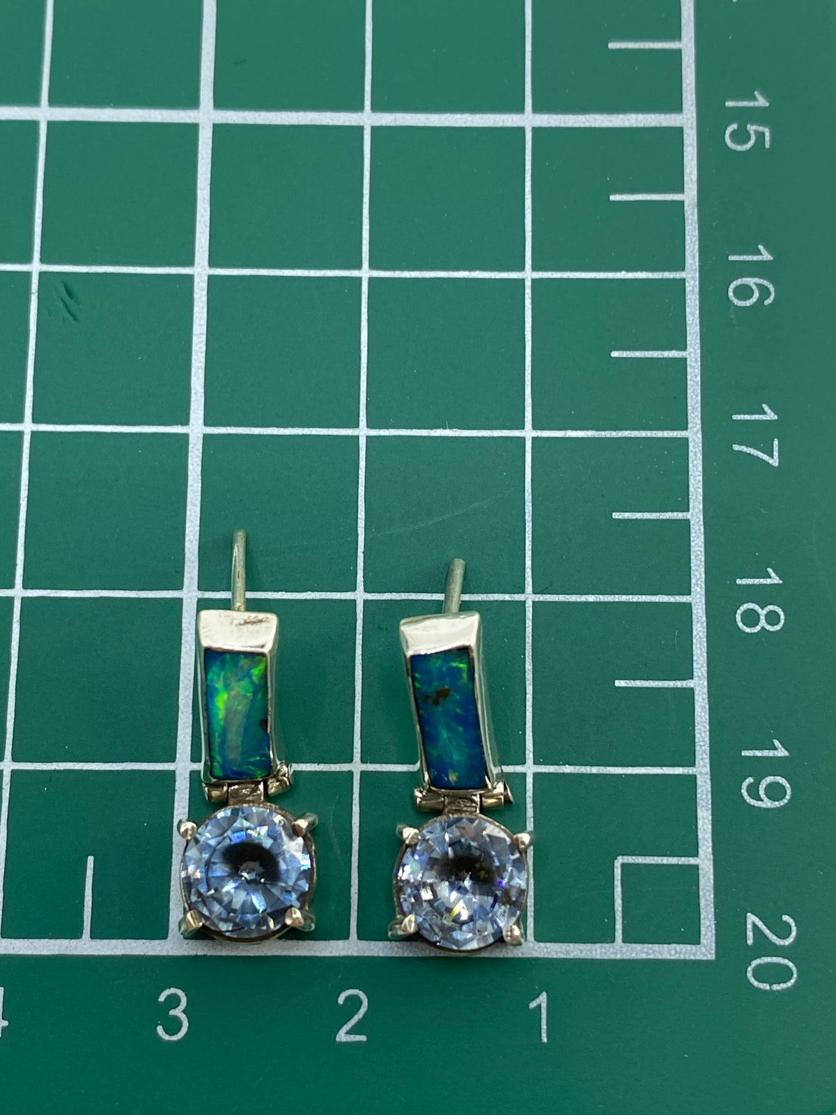 Aretes sobre fondo azul mostrando los reflejos del ópalo de fuego
