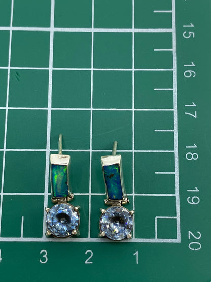Aretes sobre fondo azul mostrando los reflejos del ópalo de fuego