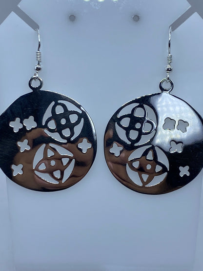 Aretes de plata calado sobre regla de medición mostrando largo de 5.6 cm