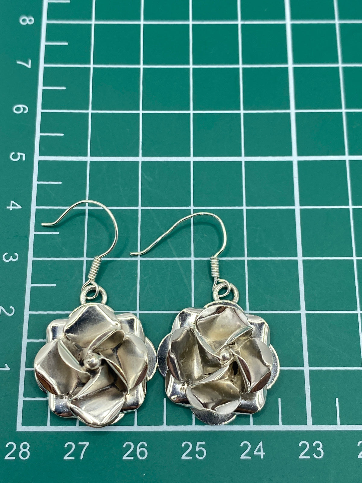 Aretes de rosa de Taxco sobre fondo blanco con el Quinto 925 visible