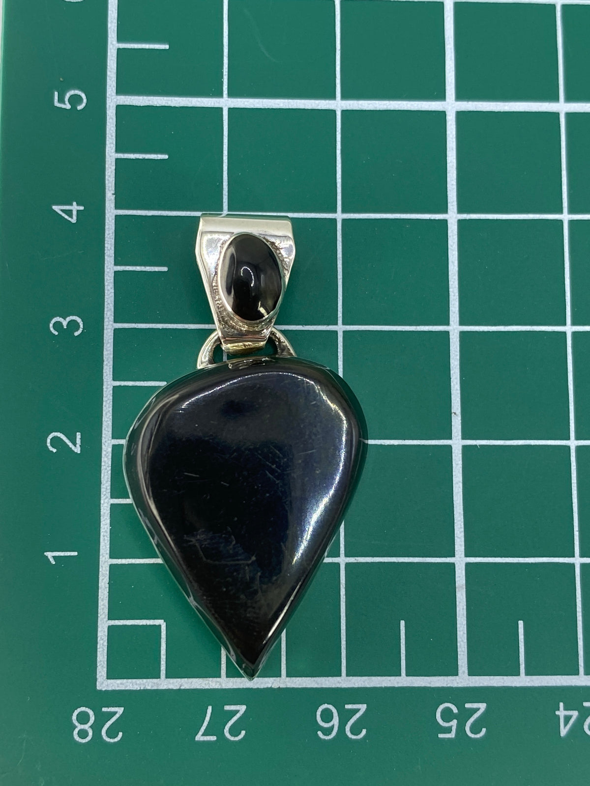 Reverso del dije corazón en plata, con marca de Quinto 925 visible.
