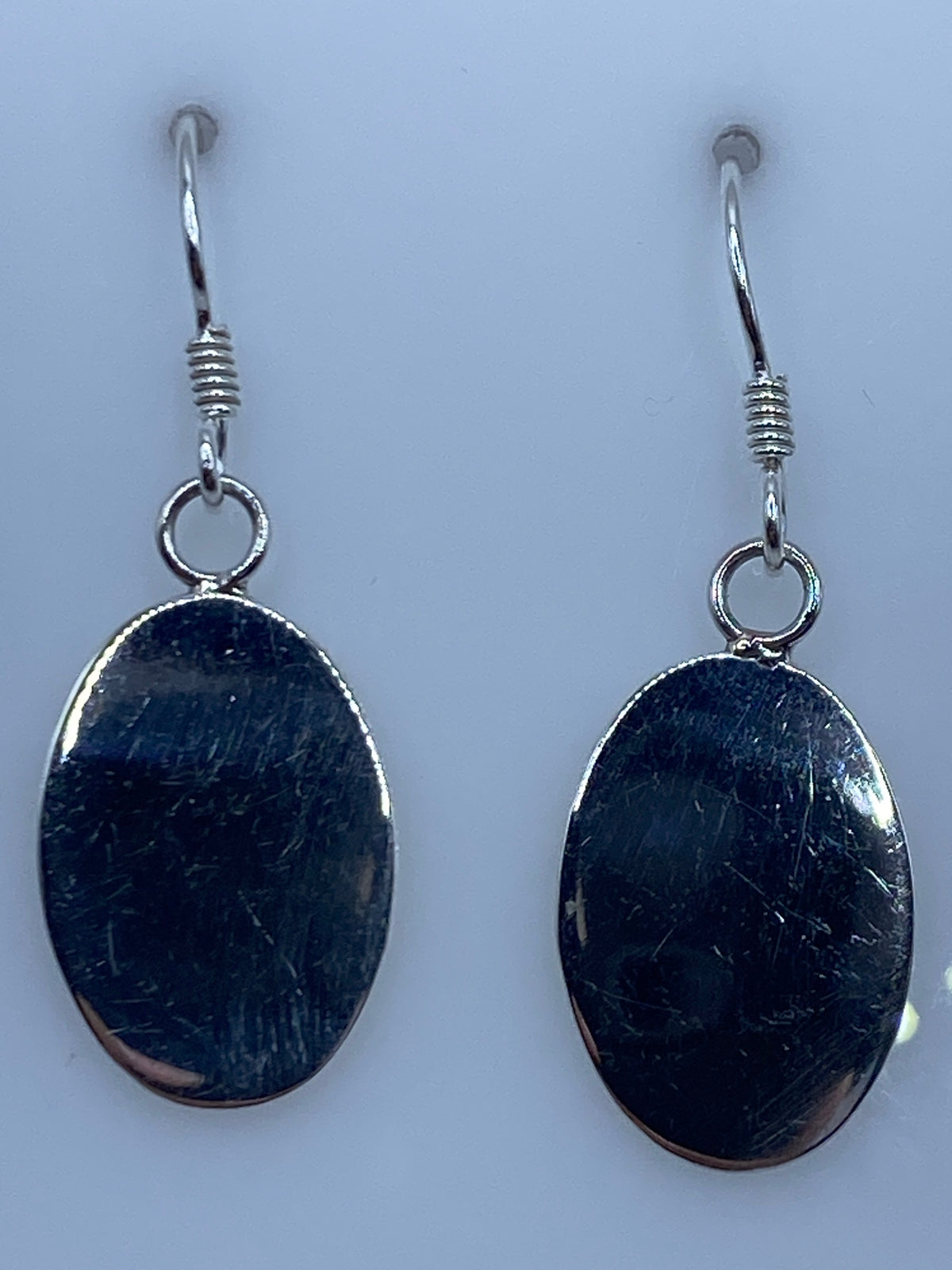 Par de aretes ovalados de plata 925 pulida, colgando con elegancia minimalista