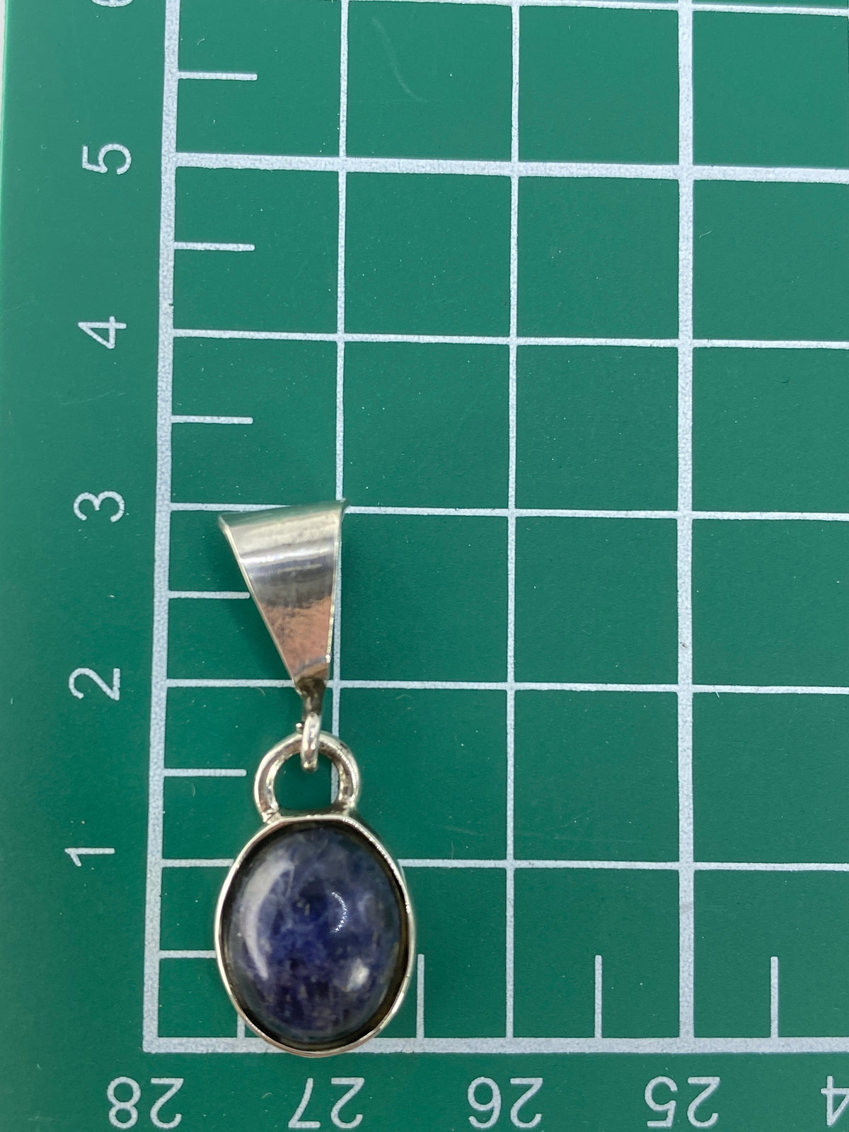 Reverso del dije de plata mostrando el engaste y acabado pulido