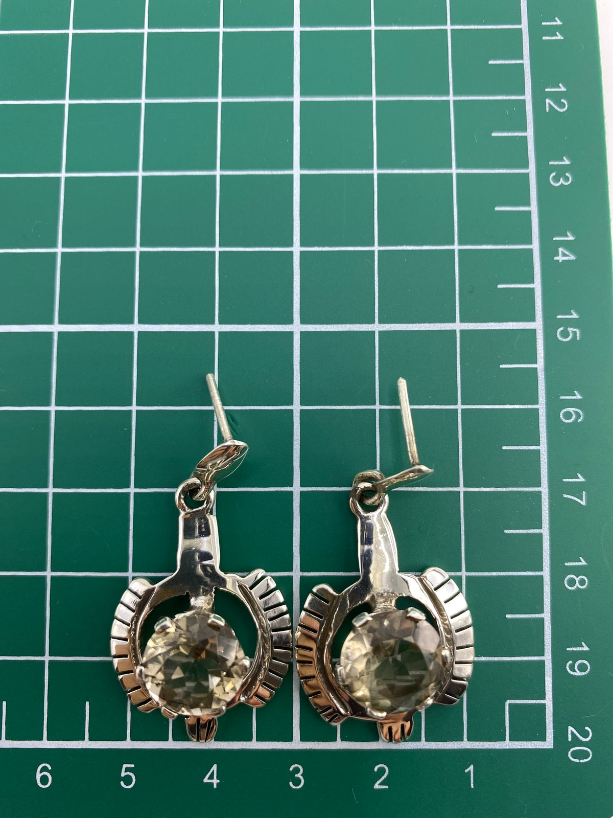 Aretes sobre fondo blanco con el Quinto 950 visible en la plata