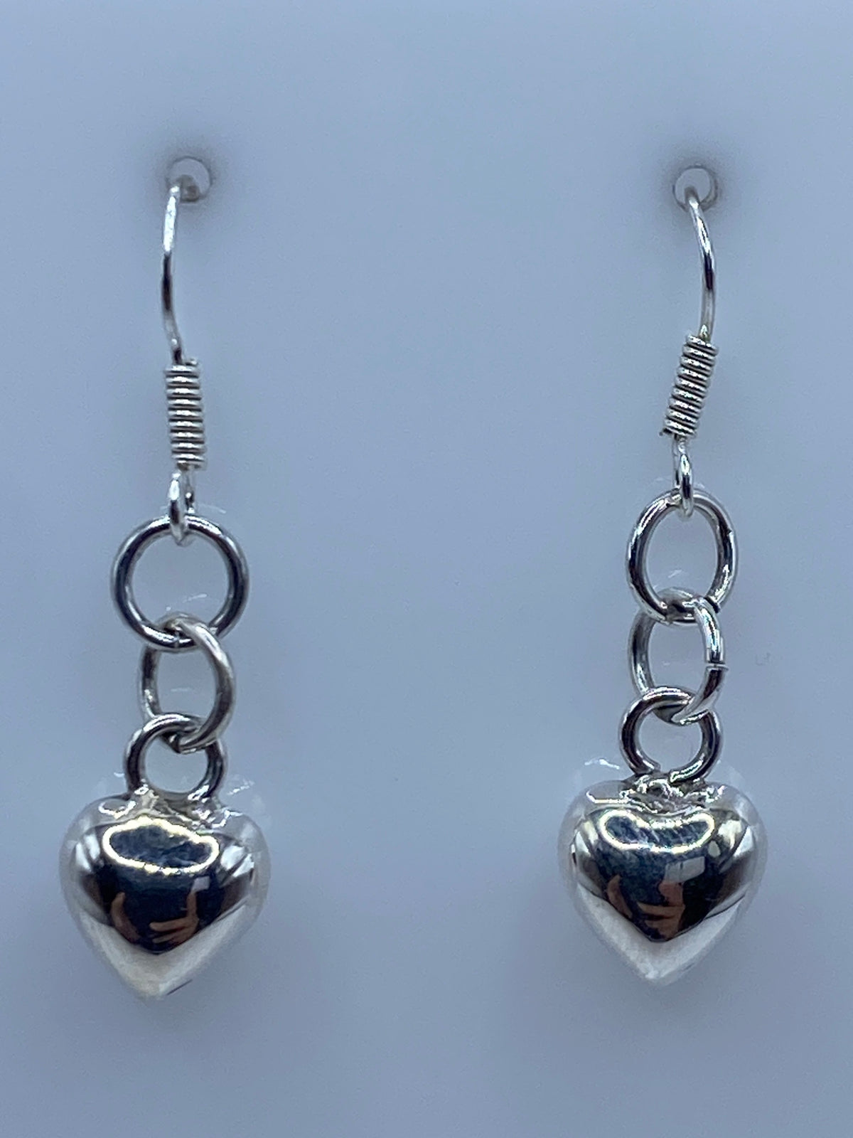 Aretes de corazón cartoneado sobre regla de centímetros, largo 3.5 cm total