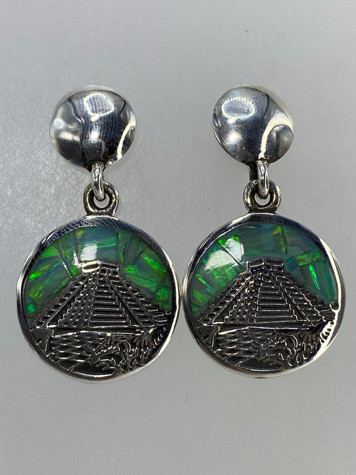 Aretes con destellos verdes, naranjas y azules del ópalo visto desde arriba