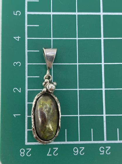 Piedra verde natural en el centro, enmarcada por la plata de Taxco