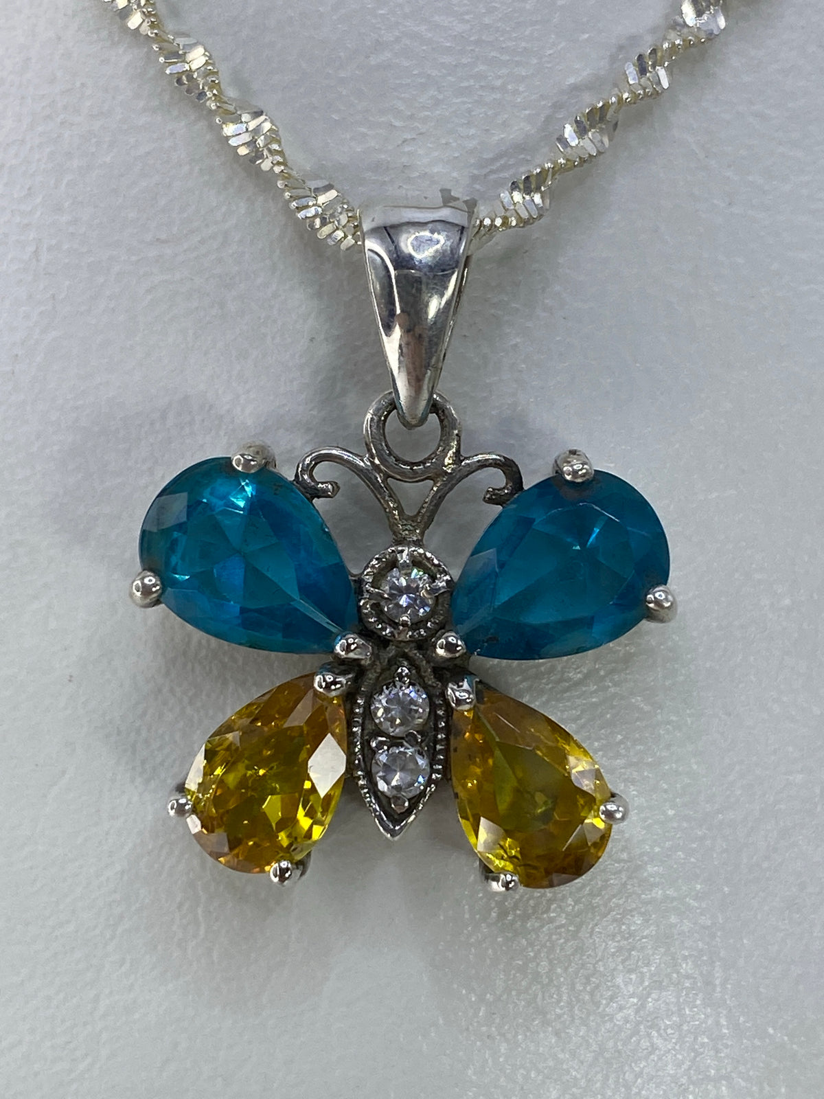 Dije mariposa de plata 925 con circonia azul cielo facetada, engaste a mano