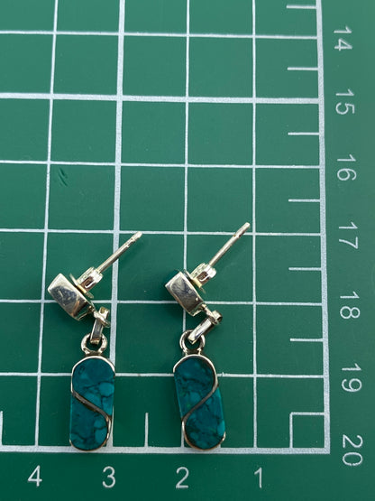 Aretes en plata 950 con marca de autenticidad, sobre fondo blanco.