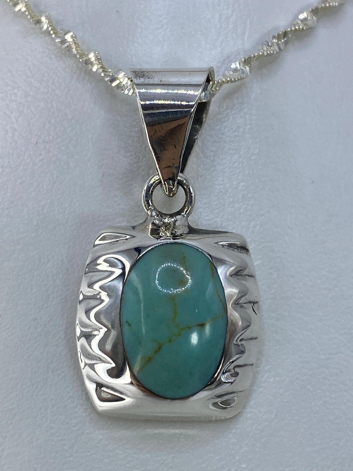 Dije cuadrado de plata 925 con turquesa azul cielo y bordes ondulantes, colgante sobre cadena serpentina
