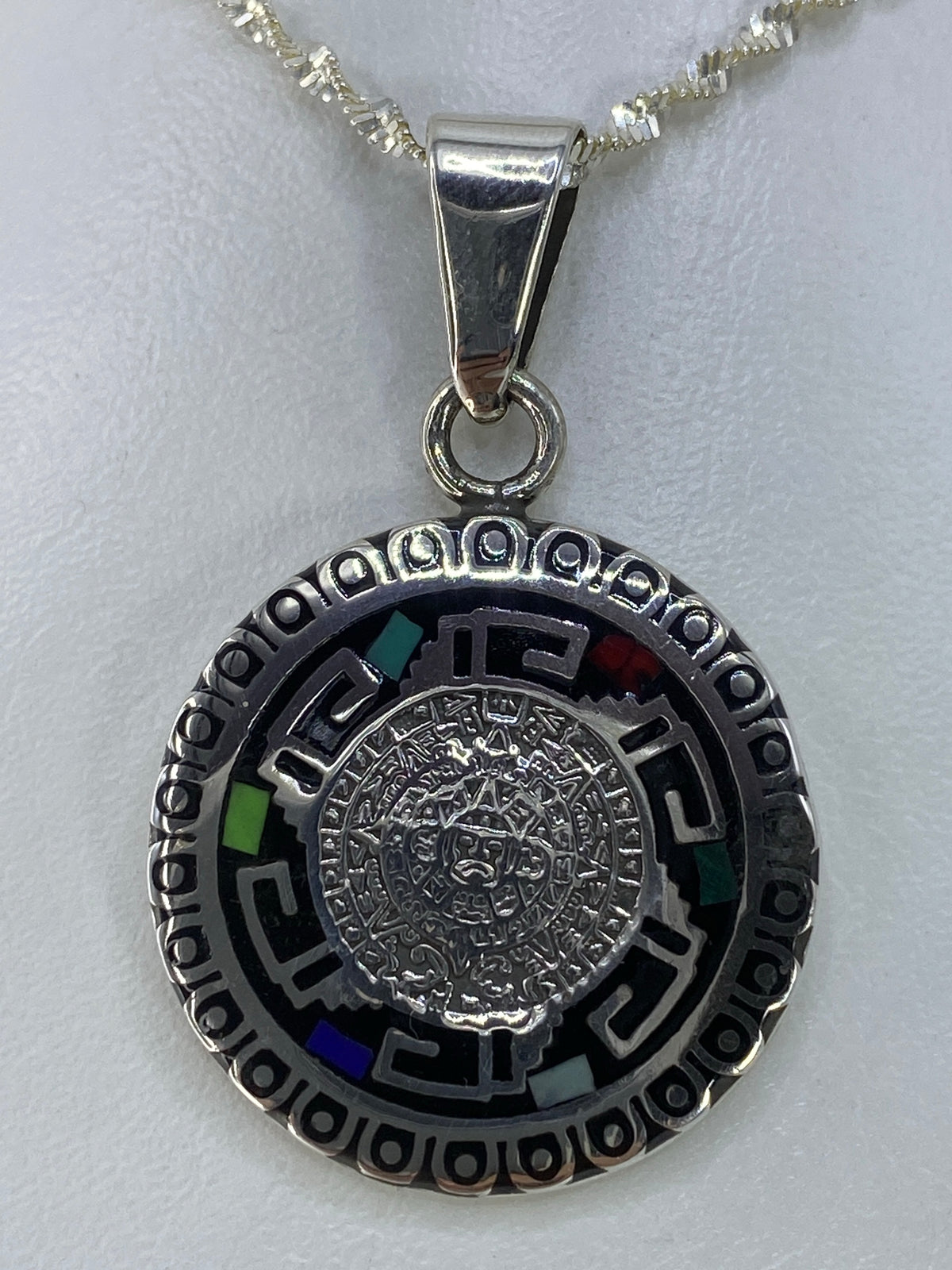 Detalle del Calendario Azteca grabado en plata con incrustación de turquesa, jade, coral y ópalo
