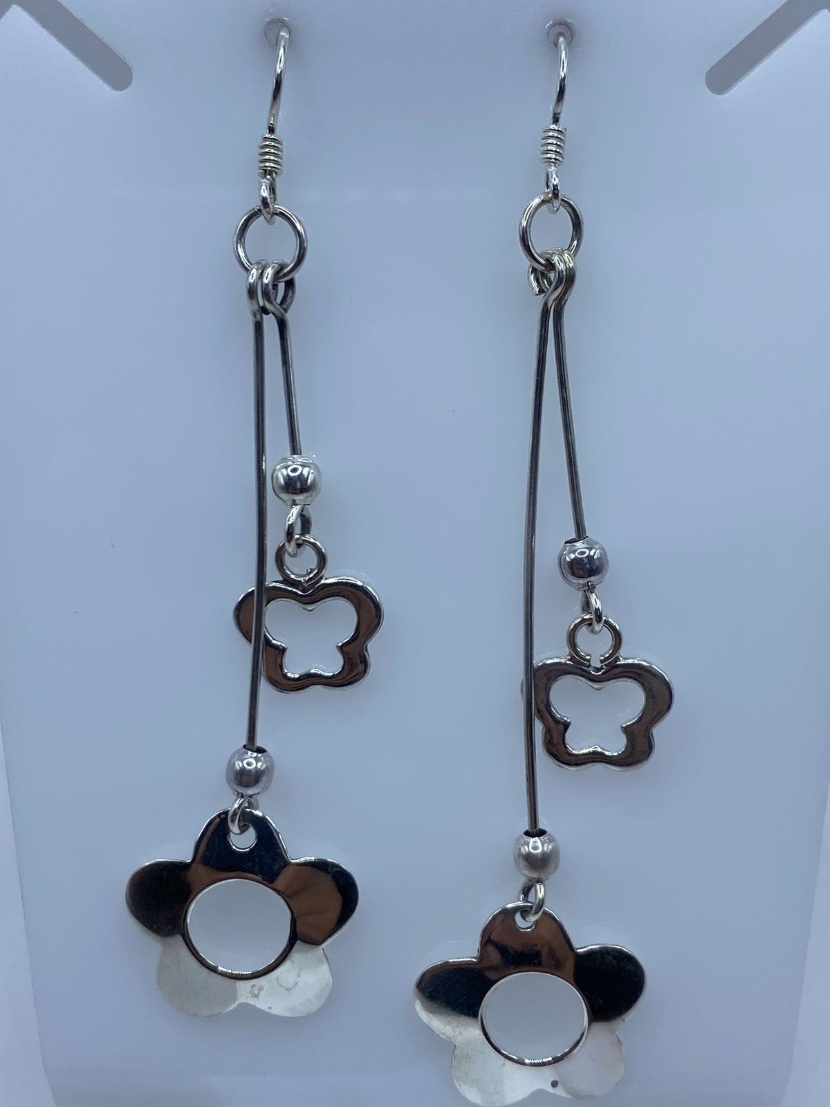 Par de aretes de plata calada con diseño floral de cuatro pétalos, largo 8.4 cm