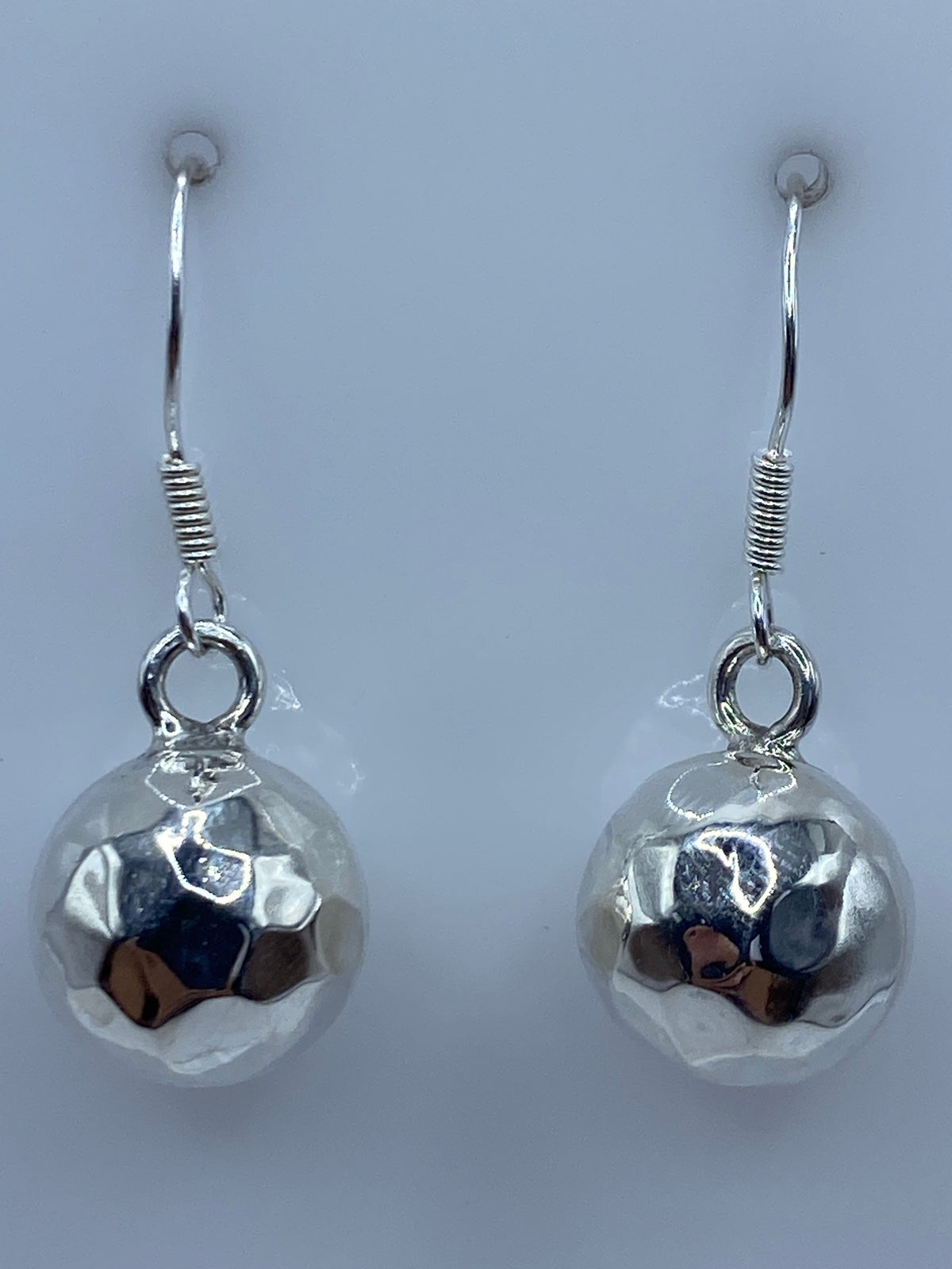 Aretes sobre escala de taller mostrando peso y tamaño real